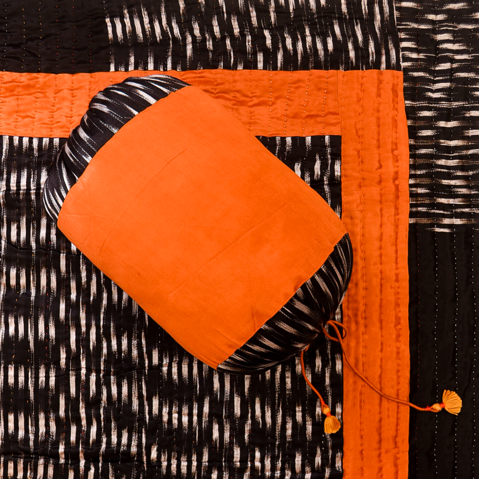 Orange fabric with black and white pattern on a textured black and white background